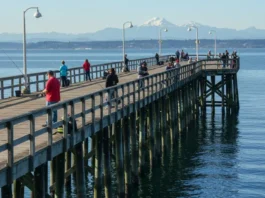 Anglers fishing on Edmonds Pier with the Puget Sound and Olympic Mountains in the background.