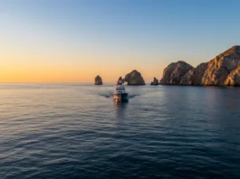 Sport fishing boat in Cabo San Lucas at sunrise in March, with El Arco in the background, highlighting the start of a prime fishing season.