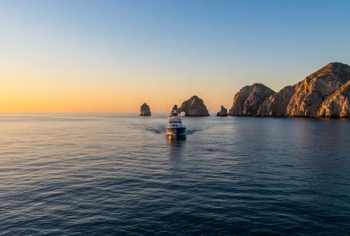 Sport fishing boat in Cabo San Lucas at sunrise in March, with El Arco in the background, highlighting the start of a prime fishing season.