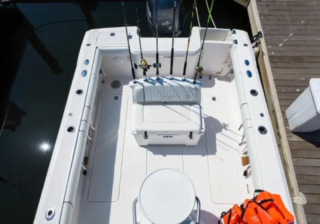 Overhead view of a charter fishing boat deck showing included items like rods, bait well, cooler, and life jackets, posing the question 'What's Included?'.