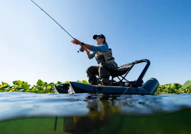Angler fishing stealthily from a float tube, casting close to lily pads on a calm lake, highlighting float tube secrets.