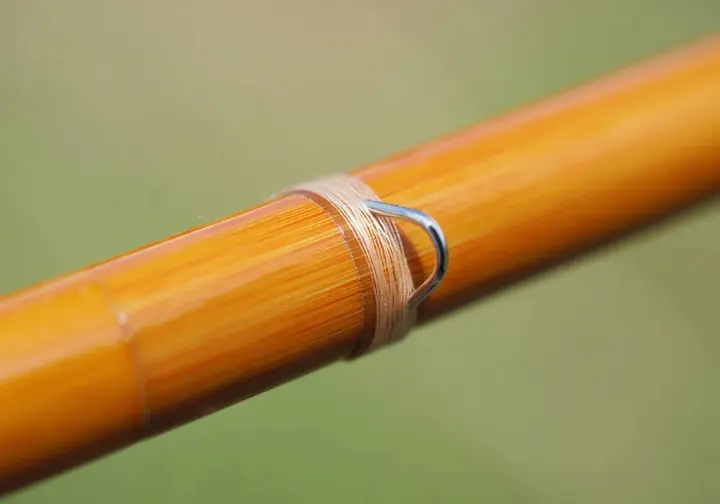 Close-up highlighting the unique natural beauty, hexagonal shape, and fine craftsmanship of a classic bamboo fly rod section.