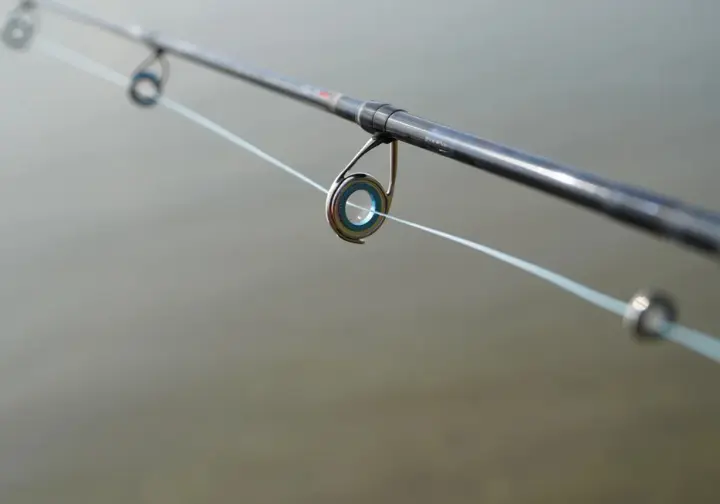 Close-up macro view showing fishing line flowing smoothly through modern rod guides, illustrating line management.