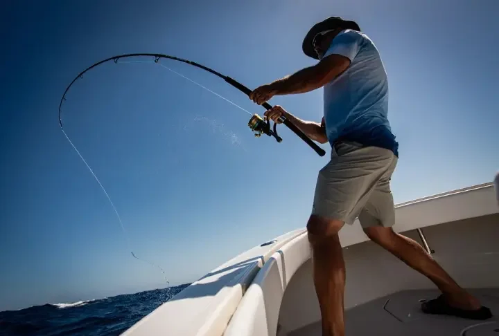 Angler battling a big fish with a top deep sea fishing rod from a boat deck in 2025.