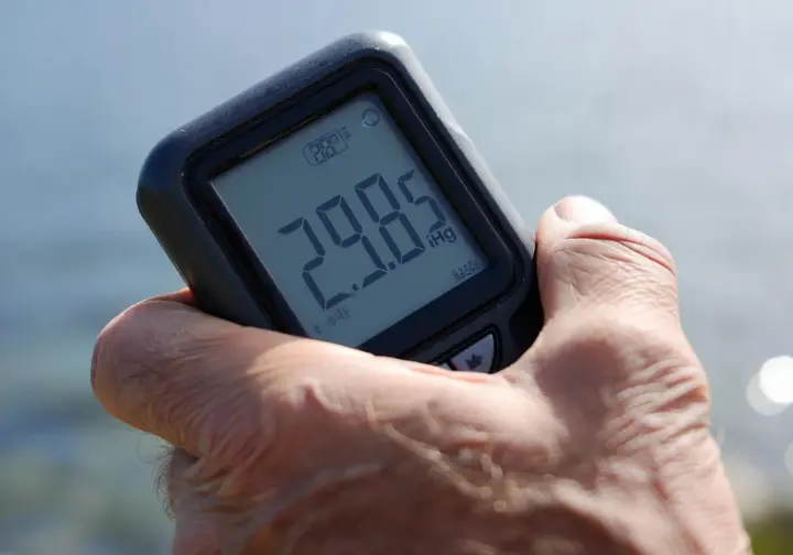 Close-up of a handheld digital barometer displaying an atmospheric pressure reading, illustrating the basics.