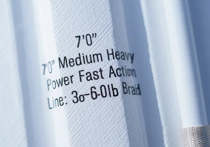 Close-up of specifications (length, power, action, line rating) printed on a saltwater fishing rod blank.