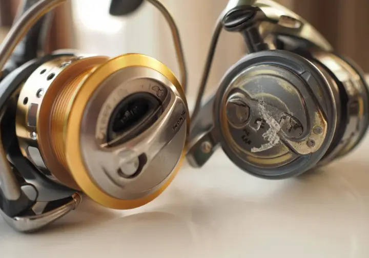 Close-up comparing a high-quality saltwater reel to a worn one, illustrating smart gear investments.