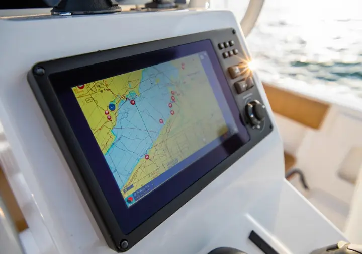 Boat's chart plotter screen displaying nautical charts and waypoints near Cabo, representing fishing hotspots.