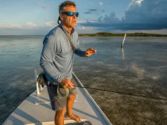 Best Polarized Sunglasses for Fishing Glass vs Poly Angler in polarized fishing sunglasses scanning a Florida Keys flat for tailing fish at first light