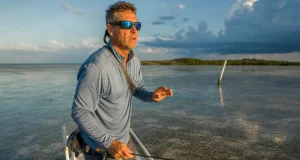 Best Polarized Sunglasses for Fishing Glass vs Poly Angler in polarized fishing sunglasses scanning a Florida Keys flat for tailing fish at first light