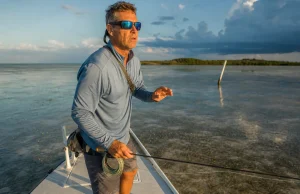 Best Polarized Sunglasses for Fishing Glass vs Poly Angler in polarized fishing sunglasses scanning a Florida Keys flat for tailing fish at first light