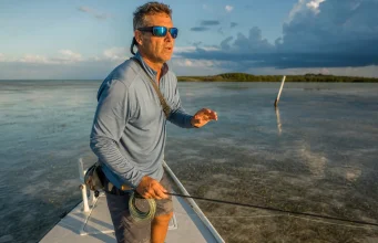 Best Polarized Sunglasses for Fishing Glass vs Poly Angler in polarized fishing sunglasses scanning a Florida Keys flat for tailing fish at first light