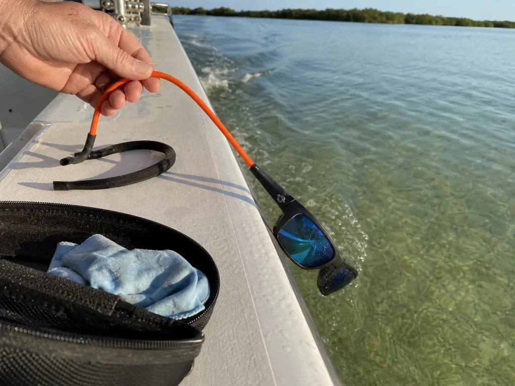 Floating retainer clipped to polarized fishing sunglasses at the gunwale to prevent losing them