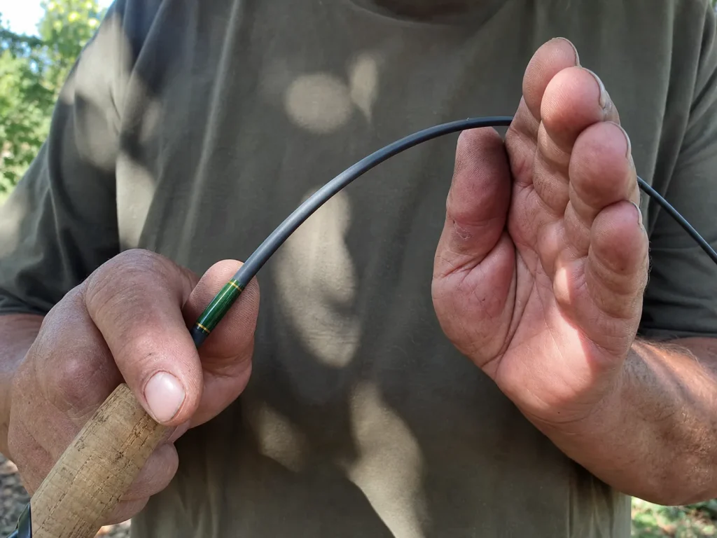 Hands flexing a spinning rod tip to show fast action bend point, rod power and action explained