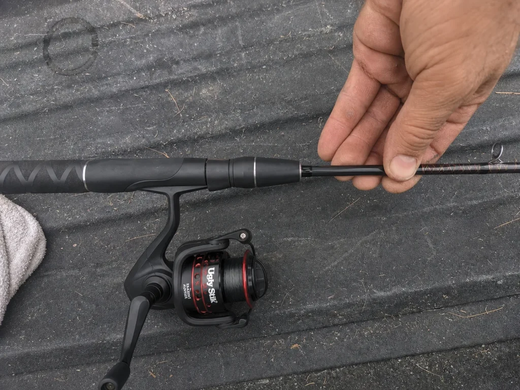 Close-up of a composite spinning rod blank and reel seat on a tailgate, graphite vs fiberglass