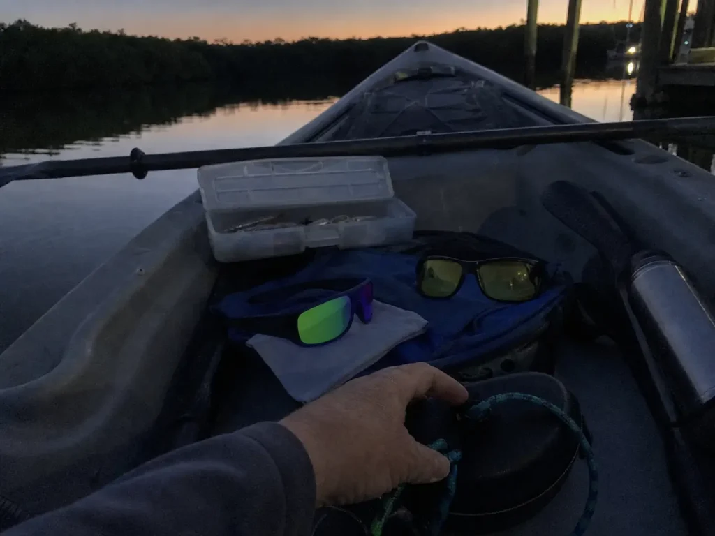 Two pairs of polarized fishing sunglasses in a kayak at dawn for changing light conditions