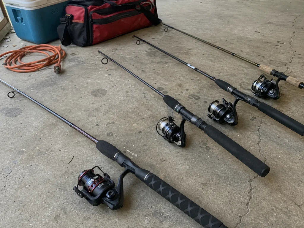 Several spinning combos laid out from budget to step-up on a garage floor, fishing rod price tiers