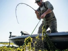 Best Braided Fishing Line: Lab Tested & Field Rated Angler leaning back on a heavy rod to pull a bass out of thick weeds using braided fishing line.