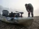 Best Fishing Kayaks Under $1000: Mod-Ready Rated A fully rigged fishing kayak sits on a gravel bank at sunrise with an angler preparing for a fishing trip.