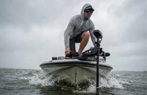 Best Trolling Motor Guide: Matching Boat & Electronics Angler on the bow of a bass boat using a trolling motor to fight heavy wind and waves.