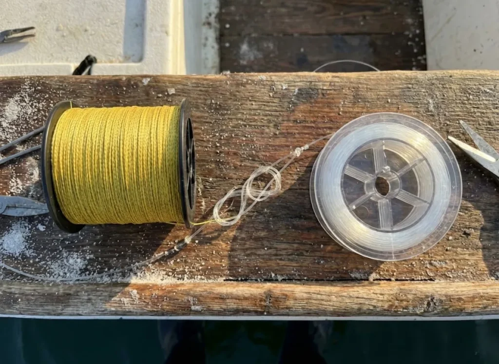 Spools of braided fishing line and monofilament line sitting on a boat deck, illustrating different material properties.