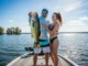 Florida Bass Lakes Ranked: A Guide to Boating a 10-Pounder A man and a woman on a bass boat in Florida, with the man holding a very large largemouth bass.