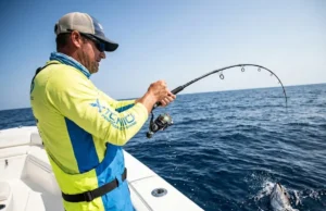 How to Set Fishing Drag: With or Without a Scale Angler fighting a strong fish with a heavily bent rod and tight fishing line, demonstrating proper drag usage.