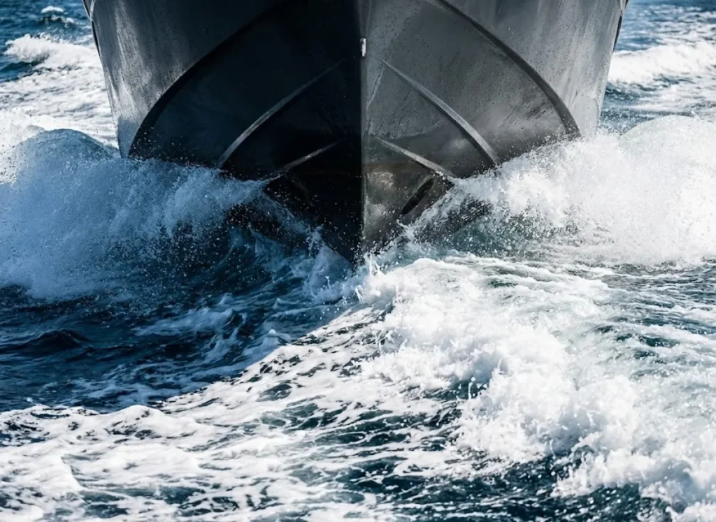 Close-up of a boat's deep-V hull cutting through a wave, illustrating hydrodynamic performance and deadrise angle