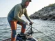 Best Trolling Motor Battery: 2026 Runtime & Buyer Guide Angler using a trolling motor to fight heavy wind and current on a lake.