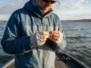 Fishing Weights Guide: Types & When to Use Them An angler threading a fishing line through a tungsten weight on a boat.