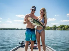 Holding Fish Correctly: A Guide to Species & Survival A man and woman on a fishing boat, with the man correctly holding a largemouth bass horizontally for a photo.
