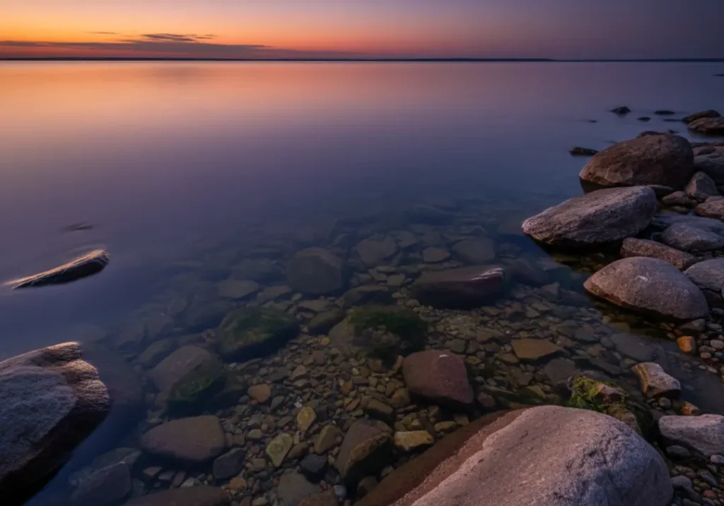 A serene view of a large, rocky lake at twilight, representing a typical Walleye habitat.