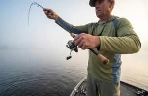 How to Drop Shot: Complete Rigging & Tactical Guide Angler fishing a drop shot rig vertically off the bow of a boat in morning mist.