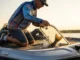 How to Use a Livewell: Complete Survival Guide Angler checking a livewell on a bass boat with water splashing from a healthy fish inside.