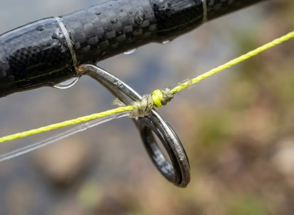 Close up of ultralight spinning reel with braided line tied to a fluorocarbon leader.