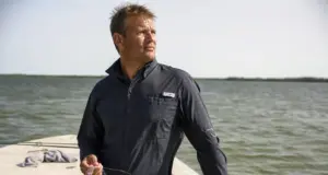 Does UPF Clothing Really Work? The Physics Says Yes Angler in a long sleeve UPF fishing shirt on open water at midmorning, sleeves down against full sun