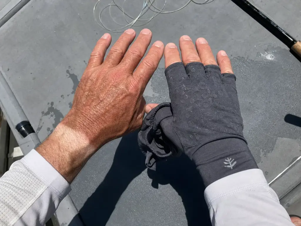 Close-up of a veteran angler's hands showing the hard tan line left by fingerless fishing gloves