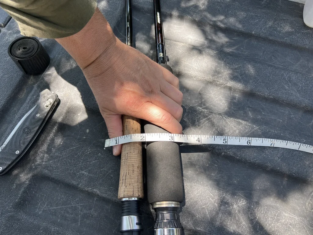 Hand wrapped around a thin rod handle with fingers overlapping, next to a thicker grip for comparison