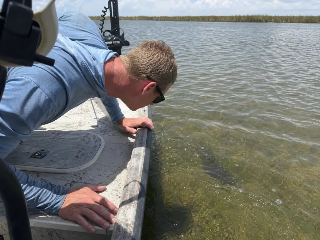 Angler tilting his head over the gunwale, the head angle that costs polarized glare blocking