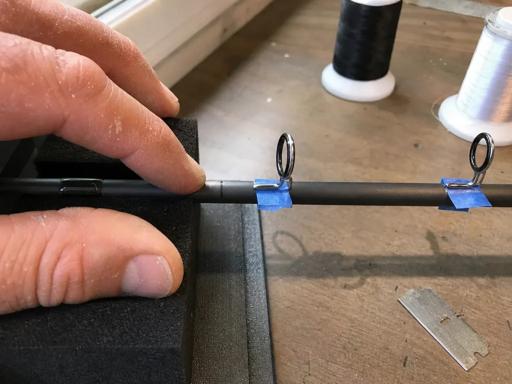 Rod guides taped onto a blank during placement showing spinning versus casting position