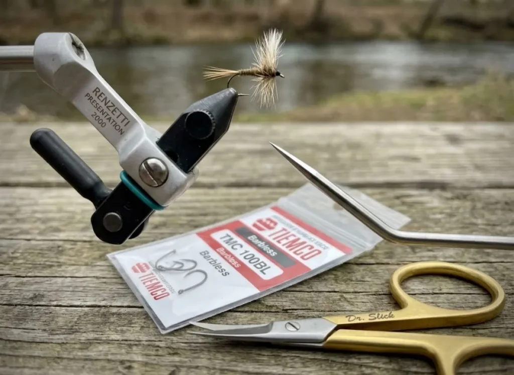 Macro shot of Tiemco barbless hooks in a Renzetti vise contrasting hook mechanics.