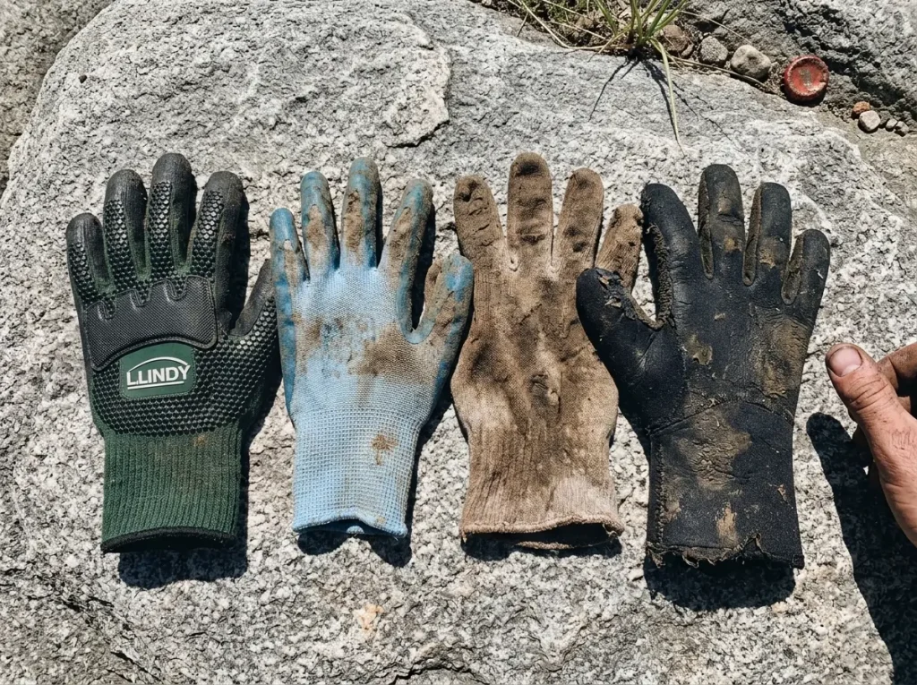 Several noodling glove materials laid out on a rock to compare puncture protection and feel