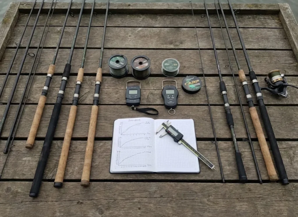 A variety of carp rods laid out on a pier with testing equipment and notes.