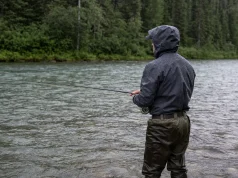 Why Waterproof Breathable Fabrics Still Leave You Wet Angler standing in a river in breathable waders and a wading jacket during light rain