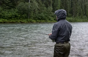 Why Waterproof Breathable Fabrics Still Leave You Wet Angler standing in a river in breathable waders and a wading jacket during light rain