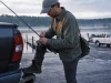 Why Your Hook Keeper Might Be on the Wrong Side Angler clipping a hook onto the rod hook keeper by the reel seat at first light on a boat ramp