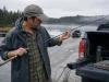 5 Mistakes That Void Your Fishing Rod Warranty Angler inspecting a fishing rod at dawn for warranty-voiding damage before a trip
