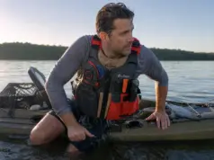 5 Kayak Reentry Mistakes That Keep You in the Water Angler in a kayak fishing PFD beside his sit-on-top after a deep water kayak reentry drill