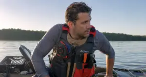 5 Kayak Reentry Mistakes That Keep You in the Water Angler in a kayak fishing PFD beside his sit-on-top after a deep water kayak reentry drill