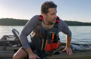 5 Kayak Reentry Mistakes That Keep You in the Water Angler in a kayak fishing PFD beside his sit-on-top after a deep water kayak reentry drill